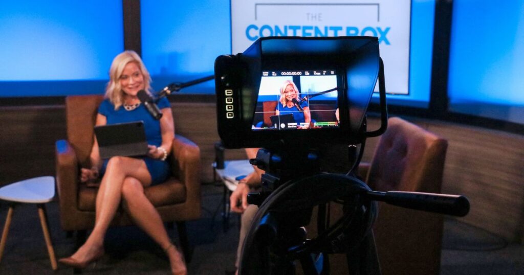 A woman seated during a podcast video recording for The Content Box.