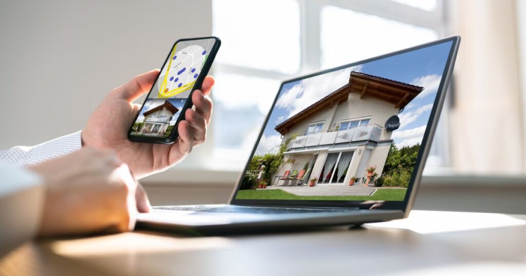 Unidentified man looking up real estate listings on a laptop and a smartphone.
