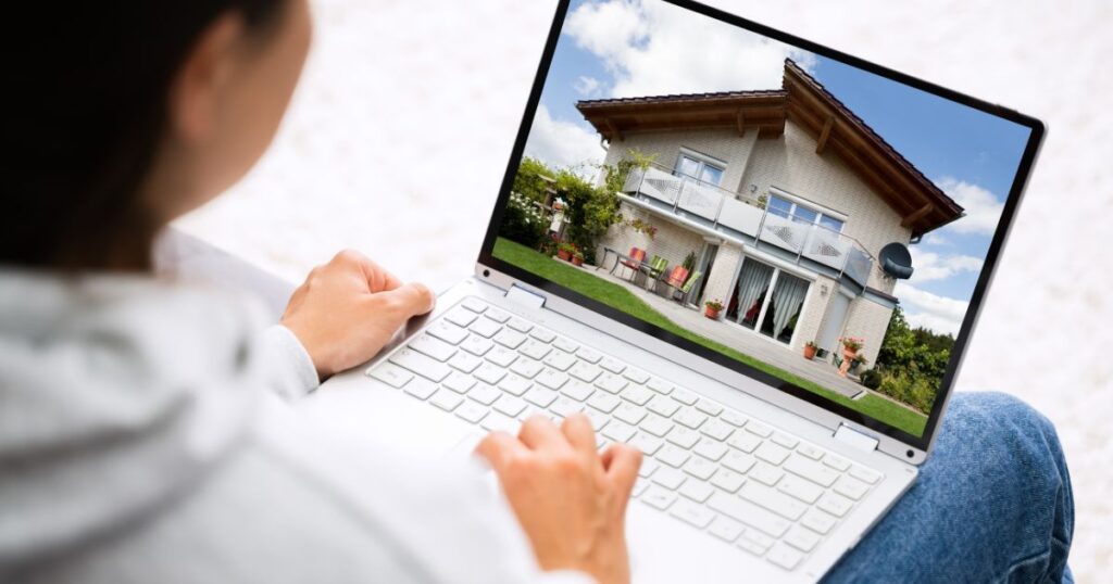 Unidentified person viewing a home on a laptop screen.