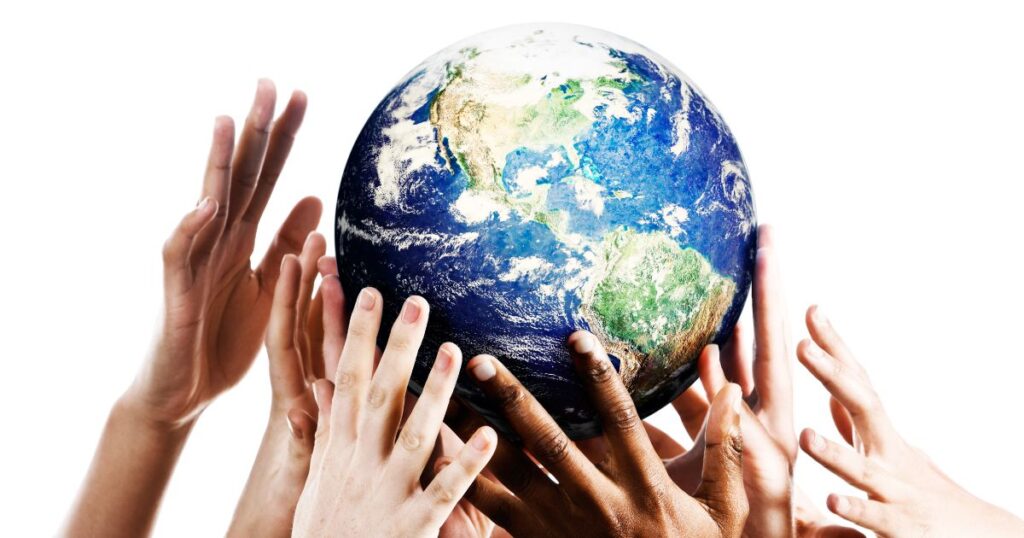 Four sets of hands holding up a ball that looks like the Earth.