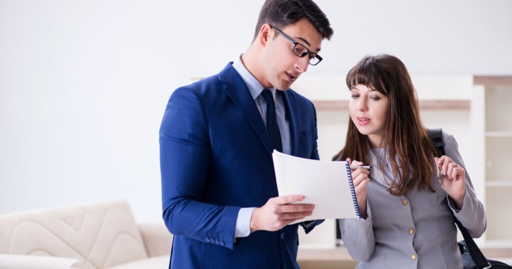 Man and woman are discussing paperwork the man is holding.