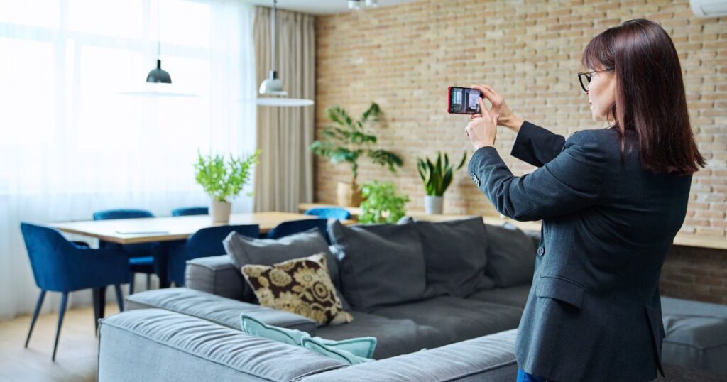 Female real estate agent using her smartphone to record media for a property.